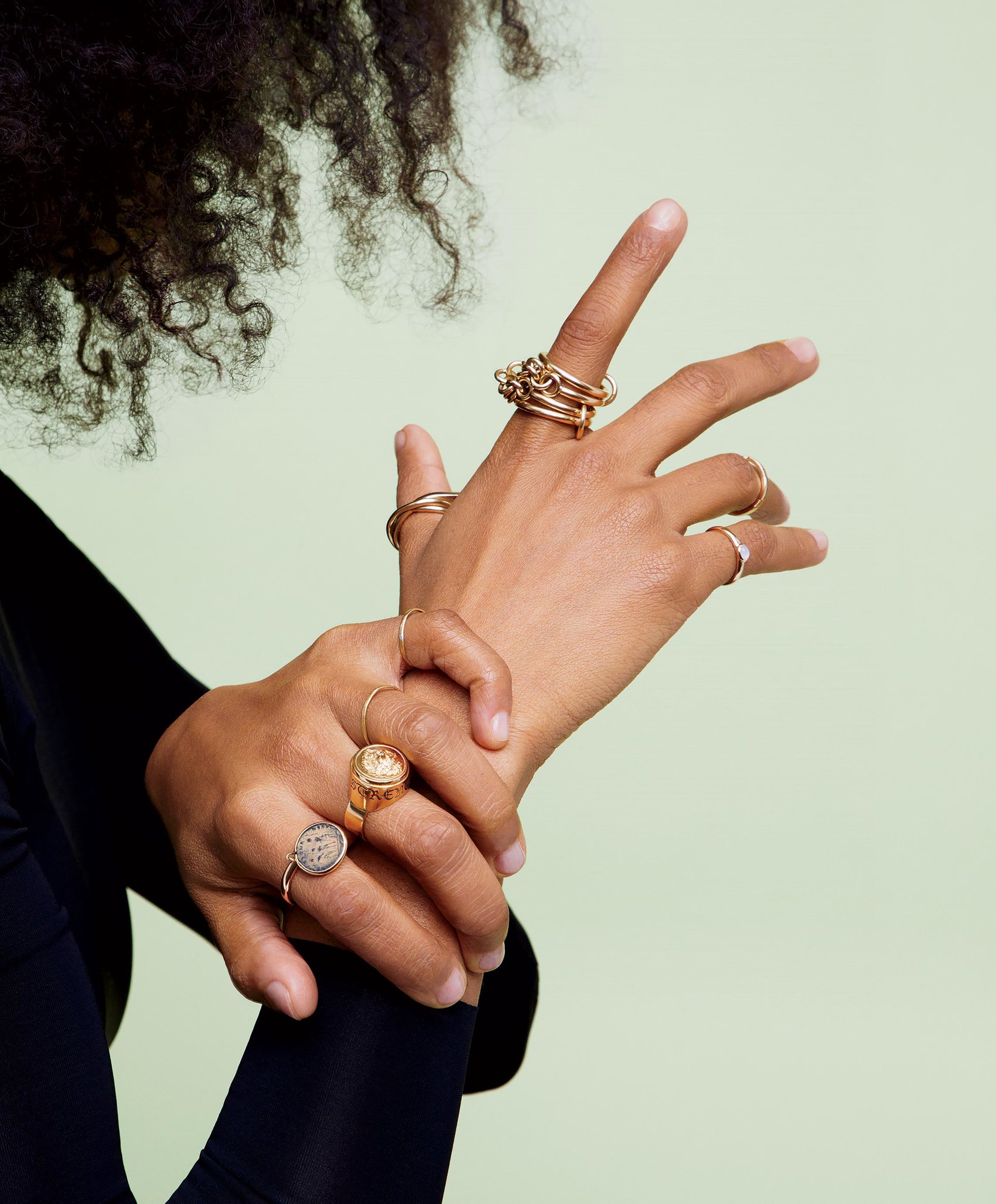 Stacked gold rings on clasped hands